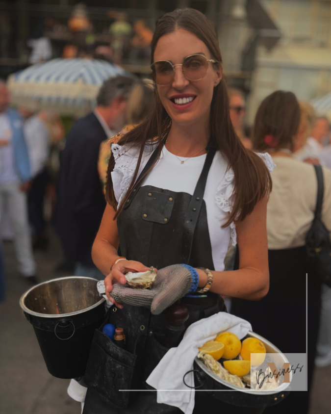 Oestermeisje serveert verse oesters tijdens exclusief feest met champagne